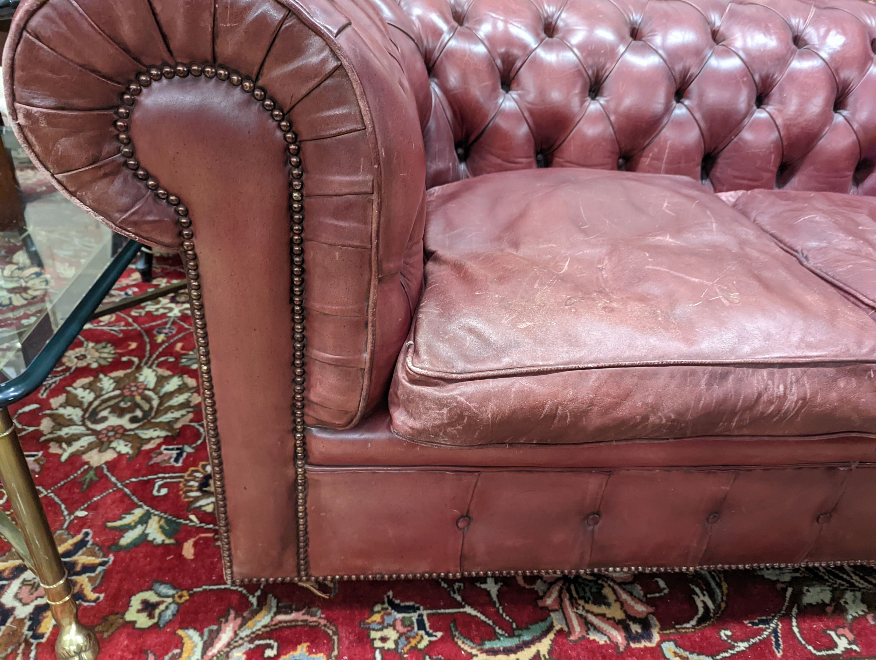 A Victorian style buttoned burgundy leather Chesterfield settee, length 172cm, depth 90cm, height 73cm